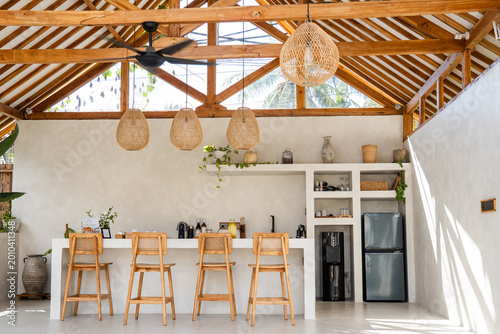 Stylish kitchen bar area with wicker lamps and exposed timber ceiling in a relaxed setting