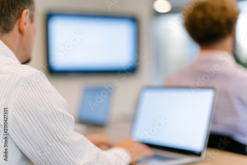Business meeting with people using laptop and screen in modern office environment for teamwork