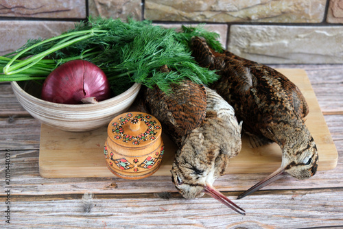 Foto Two woodcocks on a cutting board with herbs