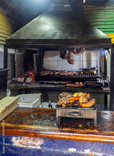 Quadro su tela Traditional Argentine Parrilla Barbecue with Assorted Meats Grilling over Hot Ch