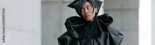 Panel kuchenny z motywem Model wearing sculptural black outfit posing in concrete setting