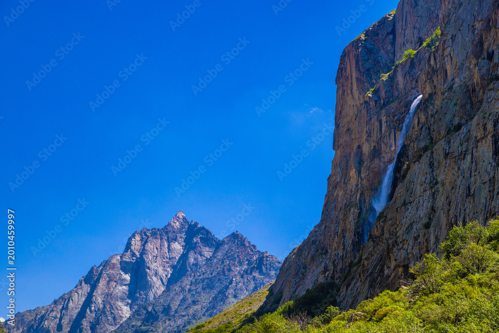 Fototapeta premium Majestic cliffs with waterfall and lush vegetation