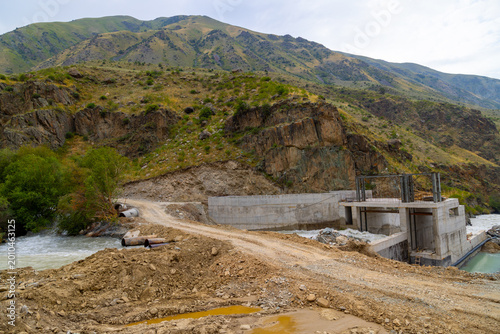 Concrete hydroelectric dam construction site in mountainous area