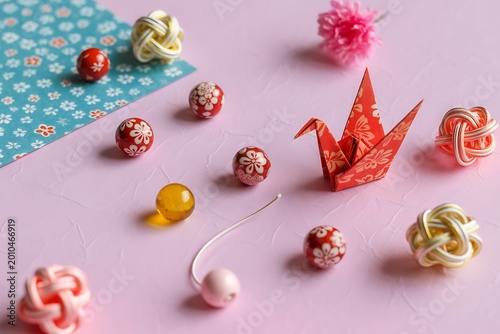 Japanese decorations including origami crane temari balls and mizuhiki adornments on pink
