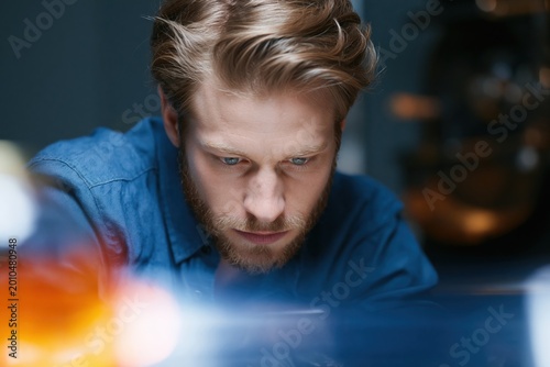 Focused Research: A skilled individual meticulously studies and examines data, showcasing an intent and dedication to solving complex problem, highlighting the power of research.