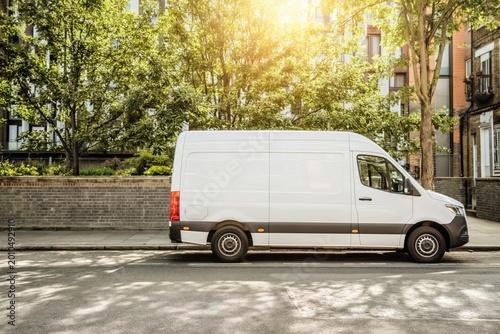 White delivery van parked on a sunny city street
