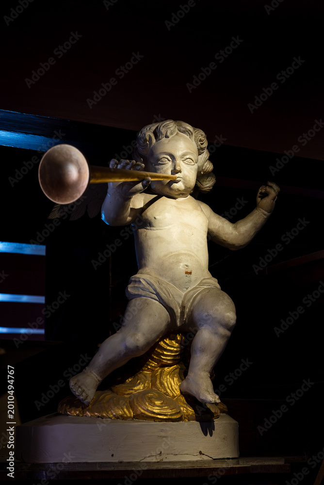 Fototapeta premium Trumpeting angel statue at Amsterdam's hidden church museum. Symbol of faith, God's message, and Dutch Golden Age spirituality