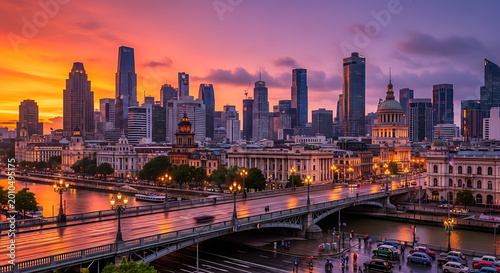 Skyscrapers at dusk during a vibrant sunset with a bridge and river in a modern city panorama