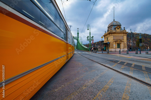 Close up of a fast moving yellow tram on a street in Budapest
