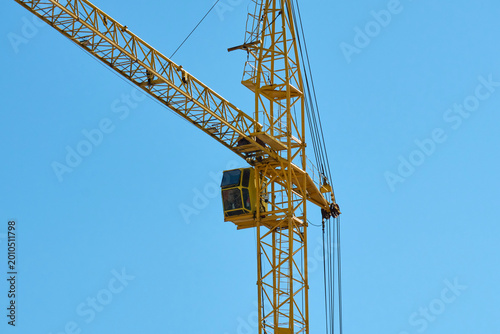 Slika na platnu A large yellow crane is visible at a construction site