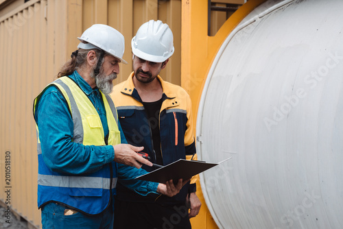 Quadro em tela Industrial engineers discussing logistics and tank container maintenance