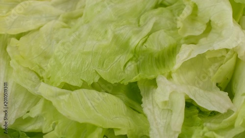 Zoom frame Iceberg lettuce with curly fresh leaves, rotation. Ingredient for a healthy salad