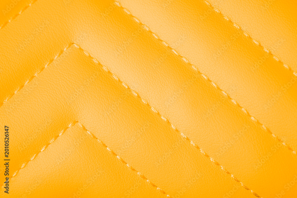Fototapeta premium Vivid orange yellow quilted faux leather texture with elegant diagonal stitching patterned background