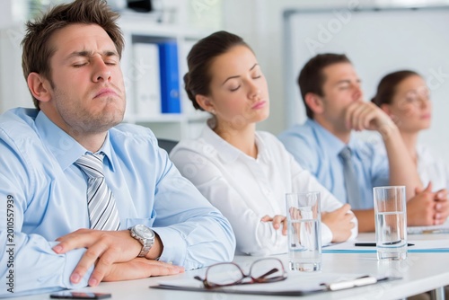Drowsy employees during workplace wellness training in corporate meeting room
