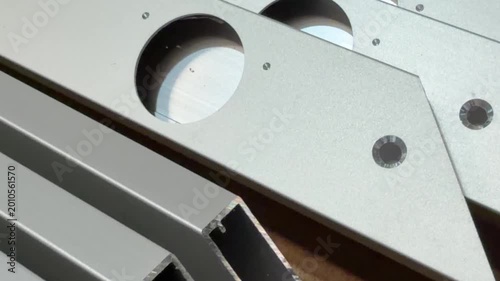A composition of aluminium profiles with hinge openings, highlighting their potential in creating innovative facade designs.