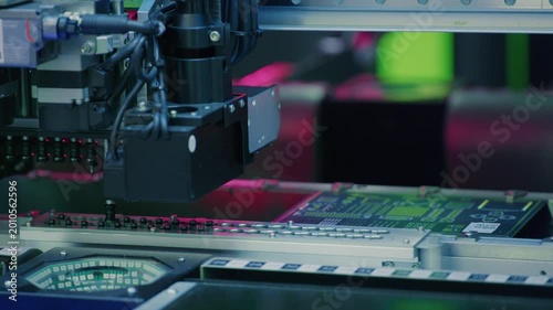 Electronics manufacturing. Automatic installation of SMT components on an electronic printed circuit board. Modern technologies. Machine installs and connects transistors and microchips on motherboard