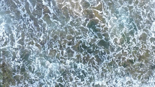 Aerial View of Ocean Waves Crashing on Rocky Shoreline