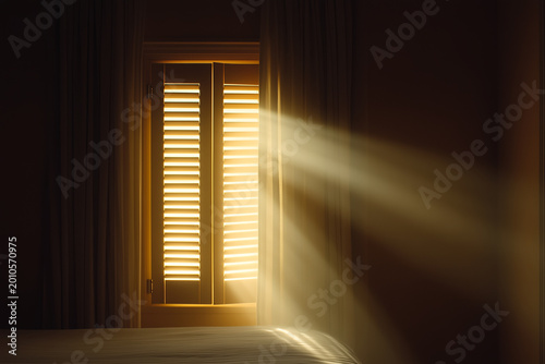 Warm sunlight streaming through wooden shutters into a dark bedroom, creating a peaceful cinematic atmosphere with cozy interior lighting and morning serenity.