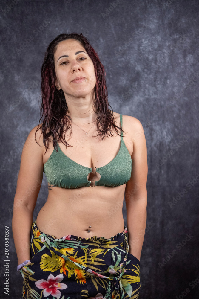 Obraz premium A woman with long dark red hair wears bikini and short. The woman is thirty-nine years old and is an Italian of Caucasian origin