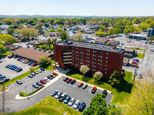 Aerial view of a multi-story red brick senior living apartment building and elderly care facility in an urban setting.