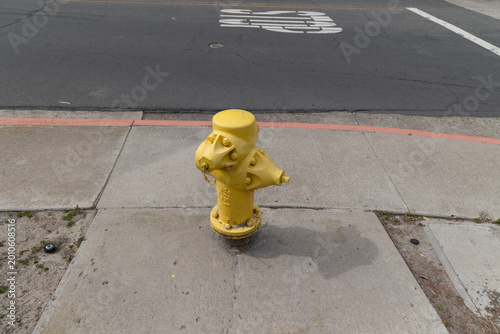 Foto Yellow fire hydrant on the sidewalk in a suburban neighborhood