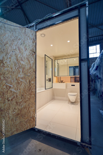 Prefabricated modular bathroom pod units in a factory with plumbing, sink, shower, bath and electrics installed ready for hotel and high rise apartment construction