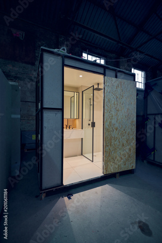 Prefabricated modular bathroom pod units in a factory with plumbing, sink, shower, bath and electrics installed ready for hotel and high rise apartment construction