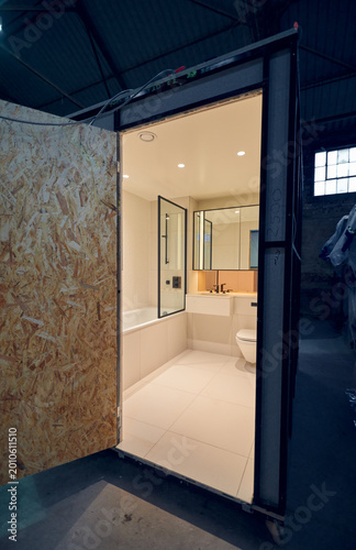 Prefabricated modular bathroom pod units in a factory with plumbing, sink, shower, bath and electrics installed ready for hotel and high rise apartment construction