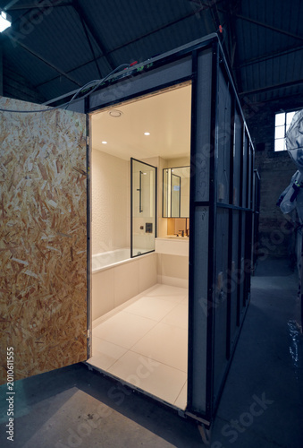 Prefabricated modular bathroom pod units in a factory with plumbing, sink, shower, bath and electrics installed ready for hotel and high rise apartment construction