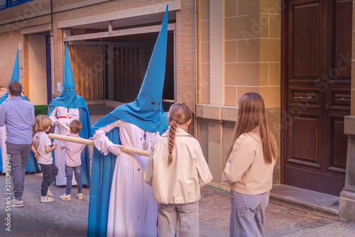 Tableau sur toile penitentes de una hermandad dandole cera de los cirios a niños para hacer bolas