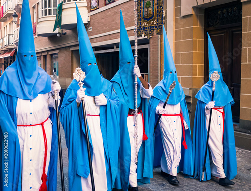 Tableau sur toile penitentes de una hermandad dandole cera de los cirios a niños para hacer bolas