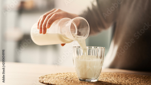 Fotografie Woman pouring milk into a glass
