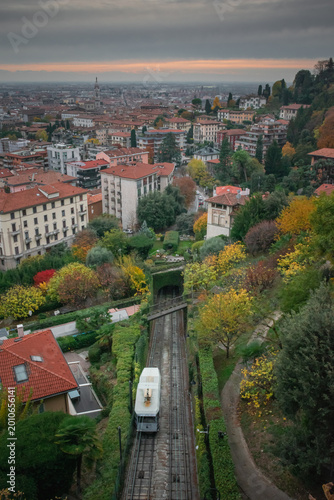 Autumn hillside funicular descending toward tunnel with panoramic city and distant towers