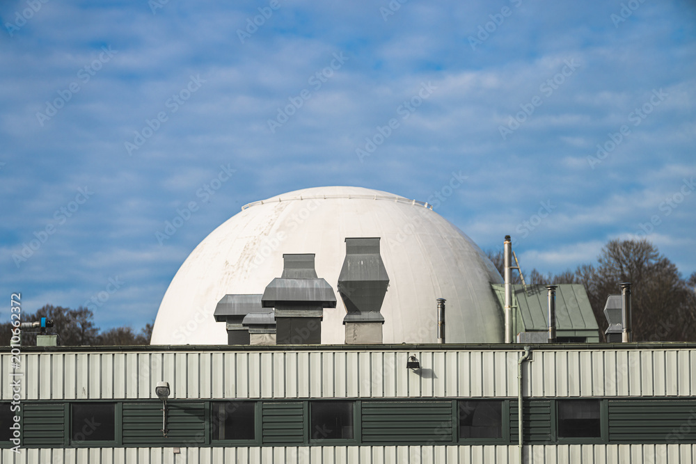 Fototapeta premium White industrial dome behind green factory roof and rooftop ventilation units.