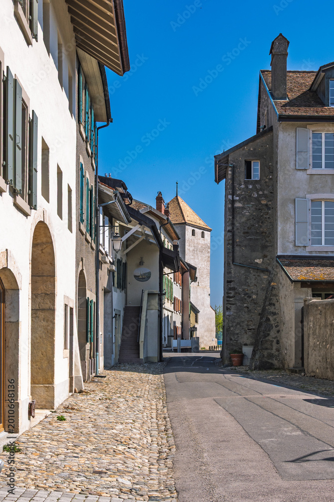 Fototapeta premium Ruelle pavée menant à la tour médiévale dans le vieux bourg de Saint-Prex, Suisse