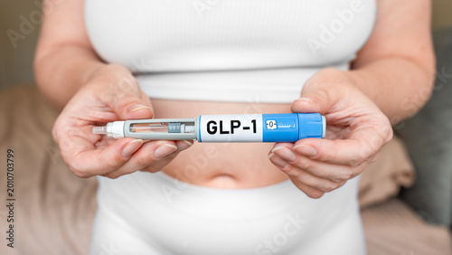 Foto GLP-1 injection pen in female hands near abdomen, weight loss and diabetes treat