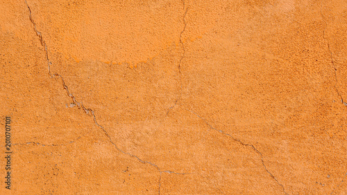 Orange plaster wall texture with cracks, rough stucco background