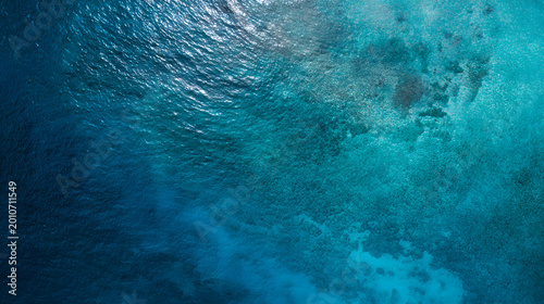 Top view of deep blue sea water surface with small ripples, aerial drone shot of turquoise ocean texture at island with abstract nature background.