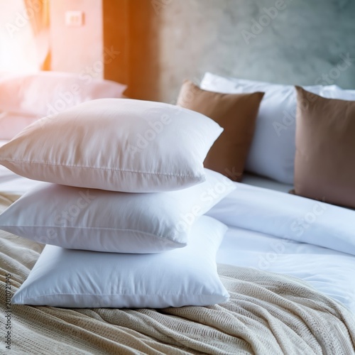 Soft Pillows Stacked on a Bed in a Cozy Room With Natural Light Coming Throug...