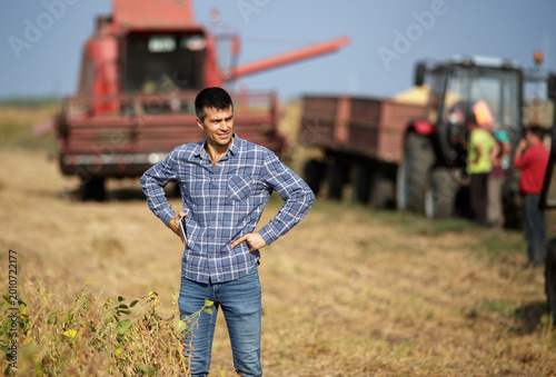 Foto Farmer standing in front of combine harvester