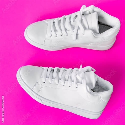 New White Sneakers on a Bright Pink Background With a Simple Design