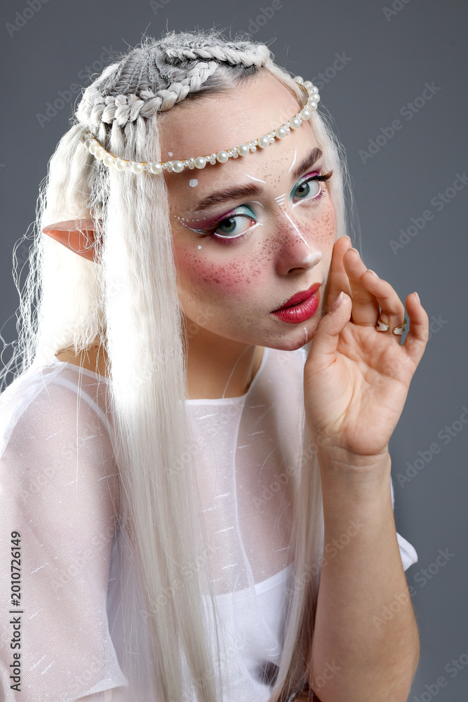 Fototapeta premium Beautiful girl dressed as elf on grey background