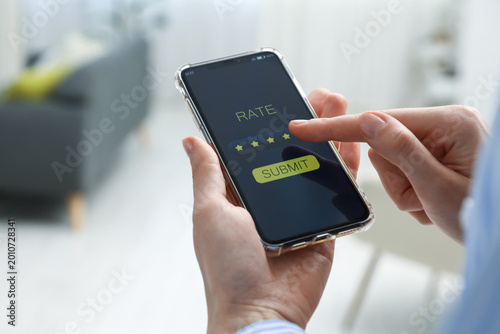 Foto Woman giving five-star rating on smartphone indoors, closeup