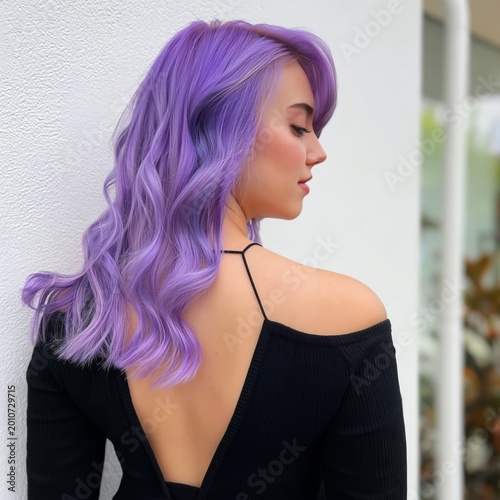 Woman With Purple Hair Poses in Backless Outfit Against a Bright Wall Outdoors