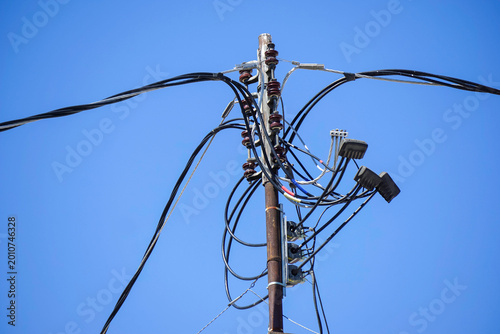 Old worn electrical power wires on urban building