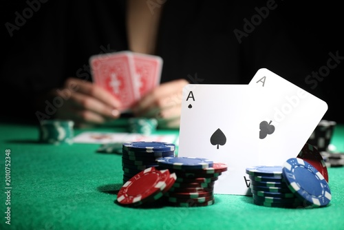 Foto Woman at green table, focus on playing card and casino chips
