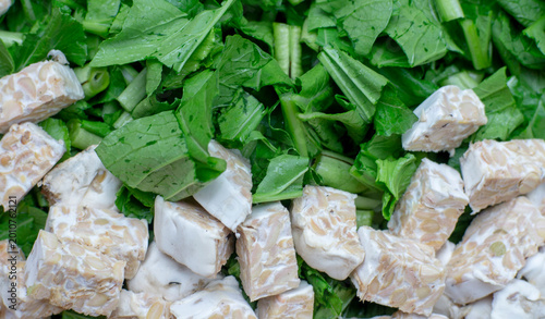 Obraz na płótnie Chop mustard greens and tempeh raw before cooking