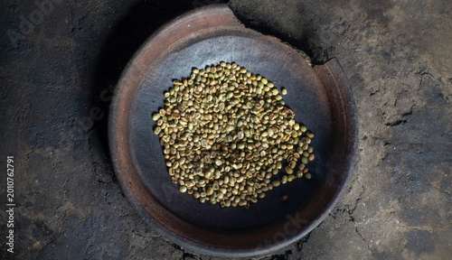 Foto Coffee beans in an earthenware pan during the roasting process