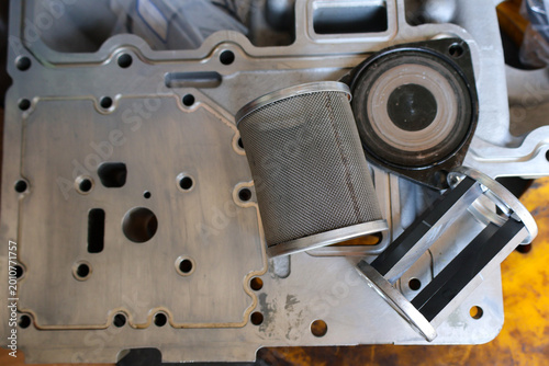 Canvas Print Detailed close up of a stainless steel mesh filter element with a machined aluminum hydraulic housing plate on a workshop table