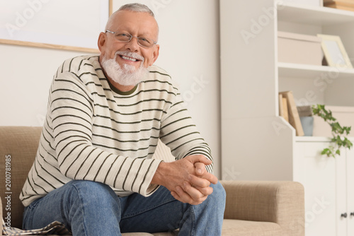 Happy senior man sitting on...